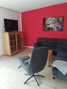 a living room with a couch and a tv at Loewe Bad Frankenhausen in Bad Frankenhausen