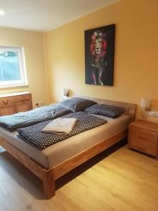 a bed in a bedroom with a picture on the wall at Loewe Bad Frankenhausen in Bad Frankenhausen