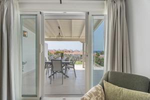 a dining room with sliding glass doors and a table with chairs at Fantastic Villa Verano in San Miguel de Abona