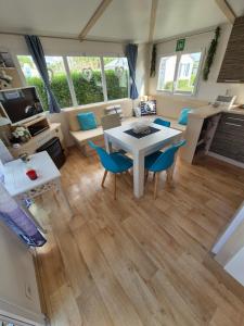 a living room with a white table and chairs at Chalet Strandliebe Bredene in Bredene