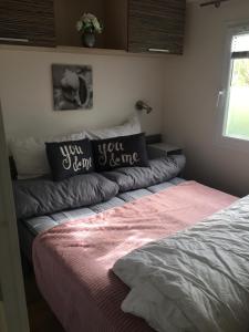 a bed in a bedroom with two pillows on it at Chalet Strandliebe Bredene in Bredene
