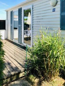 a house with a wooden deck with a patio at Chalet Strandliebe Bredene in Bredene