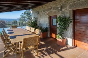 a wooden table and chairs on a patio at Lugar Da Xacra in Meder
