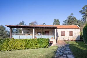 a stone house with a fence and a yard at Lugar Da Xacra in Meder