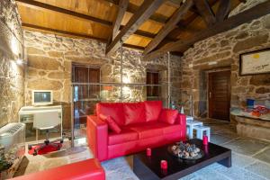 a living room with a red couch and a table at Lugar Da Xacra in Meder