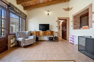 a living room with a television and a table and chairs at Mas del Vedell in L'Ampolla