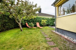 two orange chairs sitting in a yard next to a tree at Prerow Am Deich - Fewo 3 in Prerow