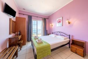 a bedroom with a bed and a table and a television at Stefanos place Studio sea View 7 in Corfu +26 photos