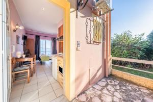 a hallway with a door open to a dining room with a table at Stefanos place Studio sea View 7 in Corfu