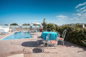 a table and chairs next to a swimming pool at Green Pearl in Lachania