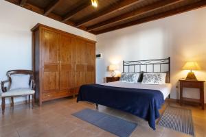 a bedroom with a large bed and a chair at Almar in Tinajo