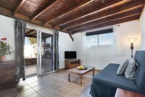 a living room with a blue couch and a table at Almar in Tinajo