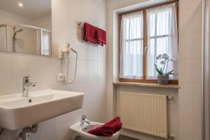 a bathroom with a sink and a toilet and a window at Haus Thurn Apartment A in Castelrotto +19 photos