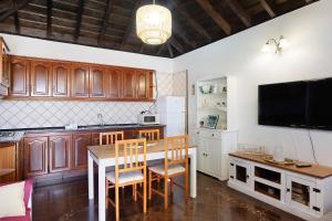 a kitchen with a table and chairs and a television at Casa La Flamenca in Tijarafe
