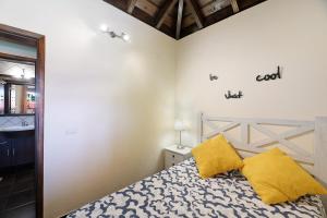 a bedroom with a bed and two yellow pillows at Casa La Flamenca in Tijarafe +13 photos