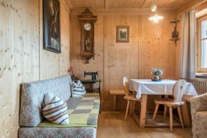 a living room with a table and a blue couch at Haus Thurn Apartment A in Castelrotto