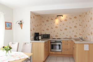 a kitchen with a stove and a microwave at Ferienwohnung Marianne in Olsberg +12 photos