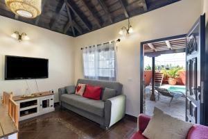 a living room with a couch and a flat screen tv at Casa La Flamenca in Tijarafe