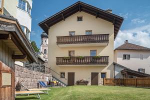an apartment building with a balcony and a courtyard at Haus Thurn Apartment A in Castelrotto