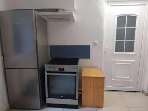 a kitchen with a refrigerator and a stove and a door at Ferienwohnung Naturglück in Sundhagen-Niederhof