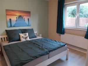 a bedroom with a bed with a painting on the wall at Ferienwohnung Naturglück in Sundhagen-Niederhof