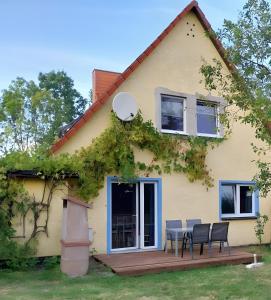 a house with a table and chairs on a deck at Ferienwohnung Naturglück in Sundhagen-Niederhof