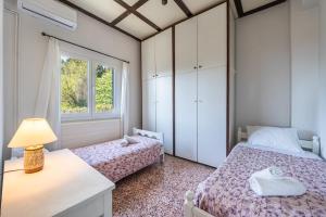 a bedroom with two beds and a window at Villa Marianthi-kaizer Bridge in Achílleion