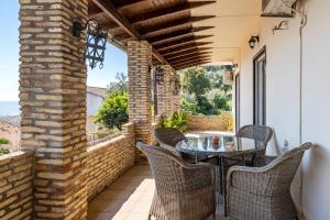 a patio with a table and chairs on a balcony at Villa Marianthi-kaizer Bridge in Achílleion