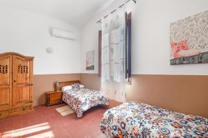 a bedroom with two beds and a dresser in it at Masa La Bomba in El Masnou +36 photos