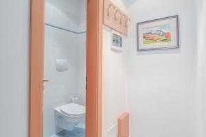 a small bathroom with a toilet and a picture on the wall at Apartments Christa App B2 in Ortisei +17 photos