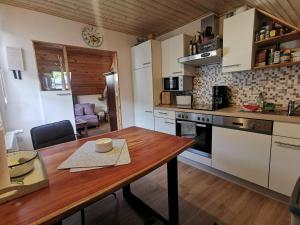 a kitchen with a wooden table and a kitchen with a stove at Haus Sonnenschein in Bad Bertrich