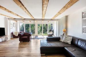 a living room with a leather couch and a tv at Ferienwohnung auf dem Wald 6 Pers in Görwihl