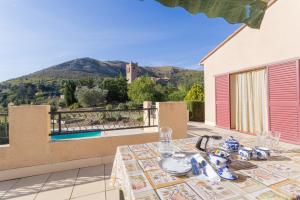 a table on a balcony with a view of a pool at Gîte dels Ocells in Camélas