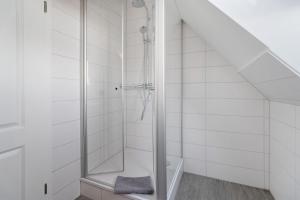 eine Dusche mit Glastür im Badezimmer in der Unterkunft Waldhusenwarft in Pellworm + 30 Fotos
