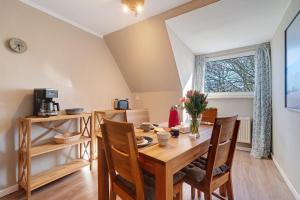 ein Esszimmer mit einem Holztisch und Stühlen in der Unterkunft Waldhusenwarft in Pellworm