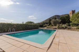 a swimming pool in a yard with a hedge at Gîte dels Ocells in Camélas