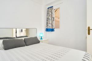 a bedroom with a large white bed with a window at Butterfly apartment in Nerja