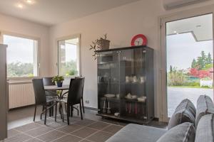 a living room with a table and a glass cabinet at Studio Colline di Bardolino in Bardolino