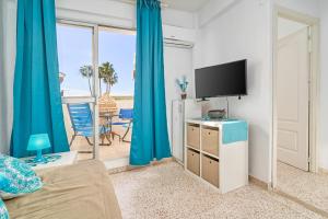 a living room with blue curtains and a tv at Butterfly apartment in Nerja