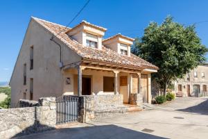 an old house with a stone fence in front of it at Casa Rural Cantueso 1 in La Matilla
