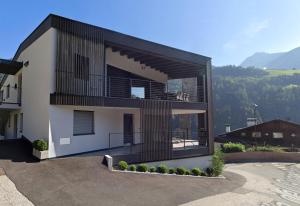 a building with a balcony with a mountain in the background at Aktiv Lodge Meran - Terrace One in San Martino