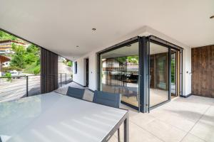 a glass house with a table and chairs on a balcony at Aktiv Lodge Meran - Terrace One in San Martino