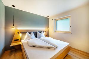 a bedroom with a white bed with a window at Aktiv Lodge Meran - Terrace One in San Martino