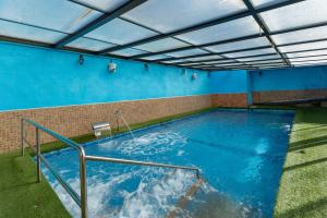 a large swimming pool in a room with blue walls at Casa Rural Kalfonso in Mascaraque