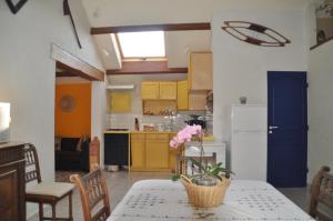 a kitchen with yellow cabinets and a table with a flower on it at Gite Chez Lucien in Trébas