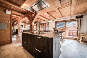 a kitchen with a large island in a room with wooden ceilings at Chalet Heidi - Chatel in Châtel