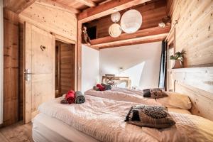 two beds in a room with wooden walls at Chalet Heidi - Chatel in Châtel