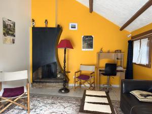 a living room with yellow walls and a fireplace at Gite Chez Lucien in Trébas