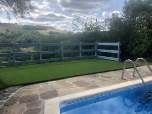 a backyard with a swimming pool and a fence and grass at Gite Chez Lucien in Trébas