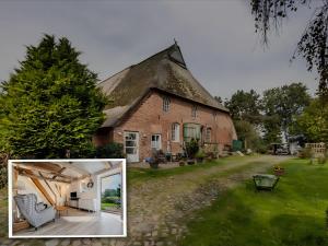 a large brick house with a thatched roof at De Olle Uhlhoff in Barlt